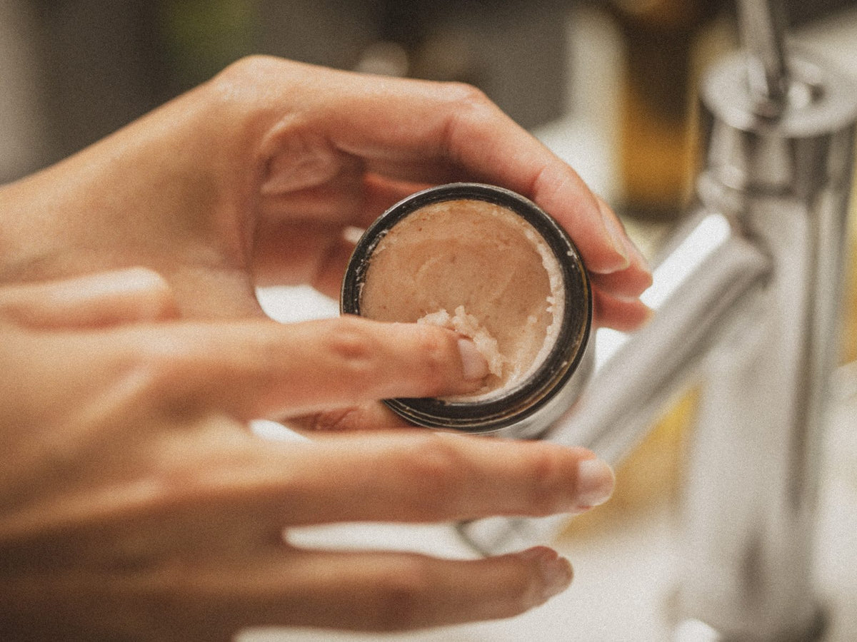 Händer med en burk balm