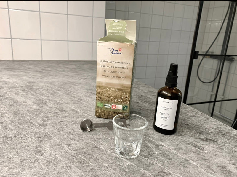 Ingredienser til hjemmelavet peeling med flormelis og olie på en marmorbordplade