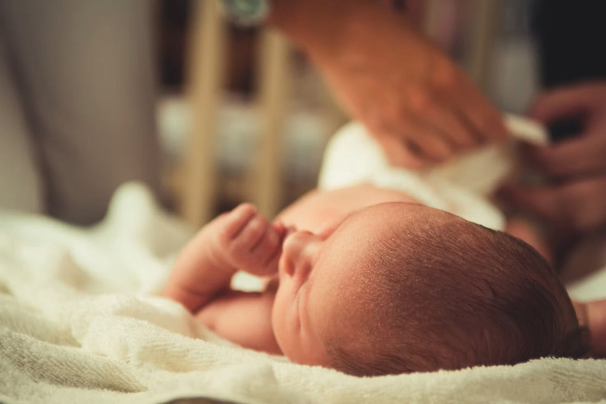 Nyfødt baby, der sover på et blødt tæppe
