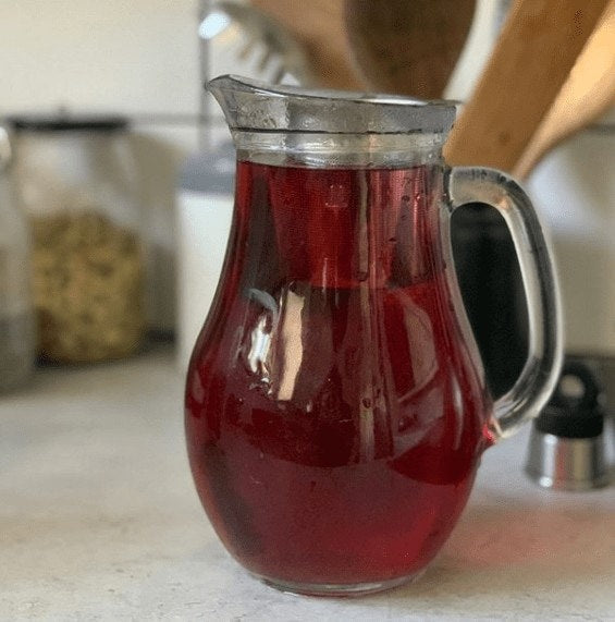 Rød hårskyl med hibiscus i en glaskande