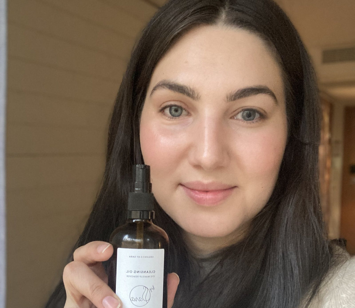 Ihoterapeutti Sara Nomberg kasvoöljypullon kanssa
