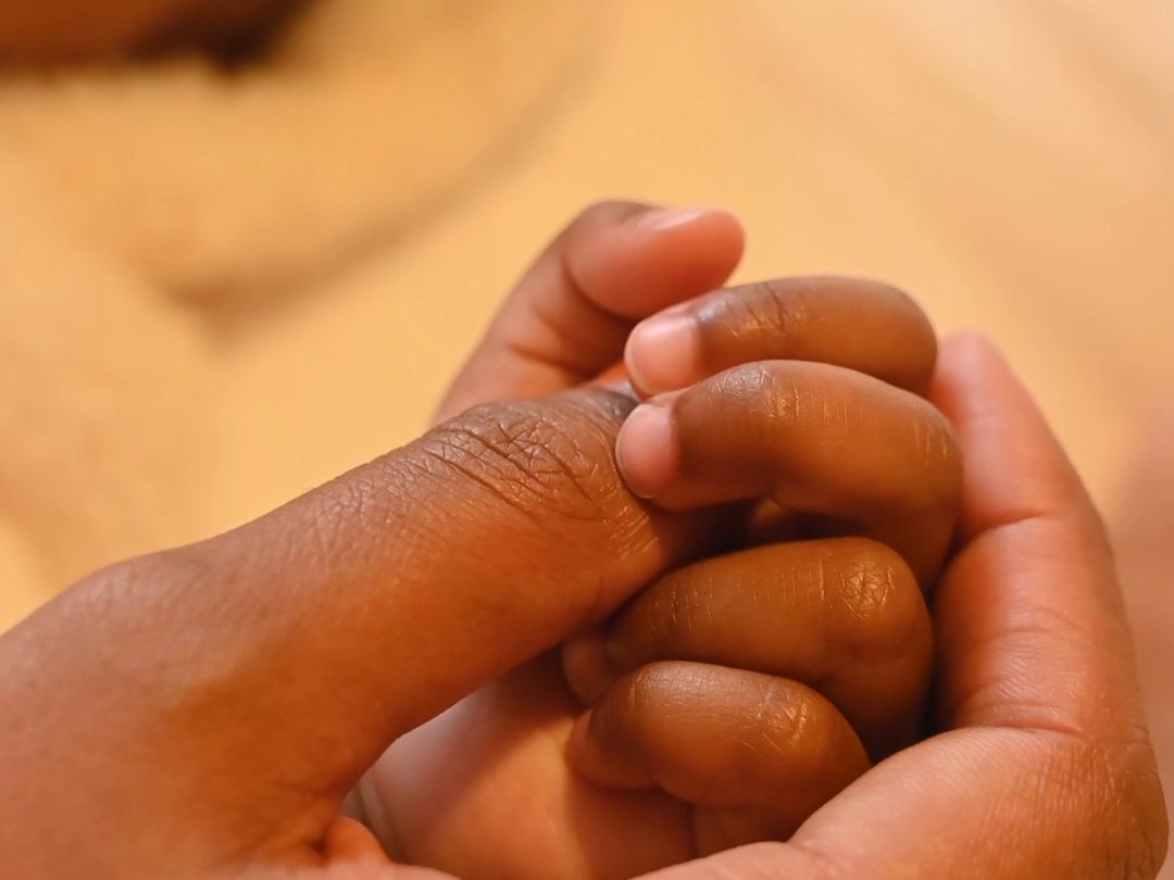 Bebis håller mammas hand