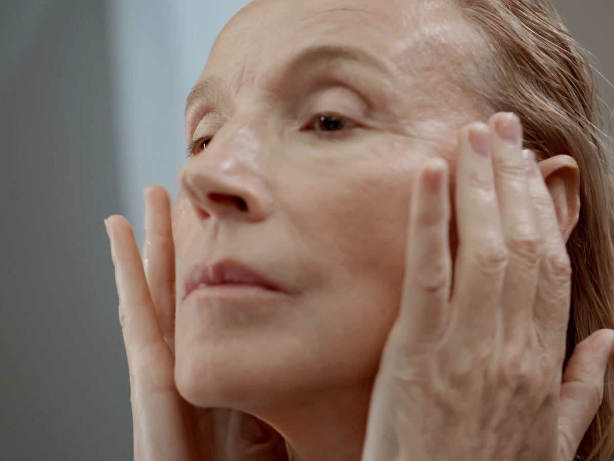 Mogen kvinna masserar in serum