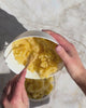 Händer blandar egen hudvård i en skål